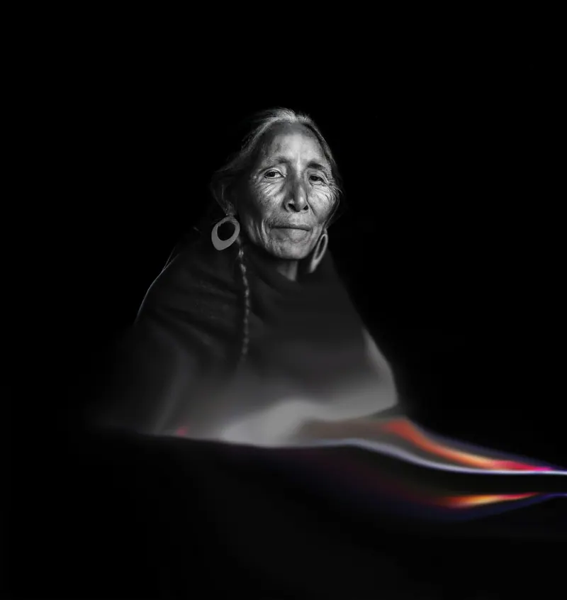 Una abuela andina generada con IA, con trenzas. Una cinta de luz cruza el encuadre.
