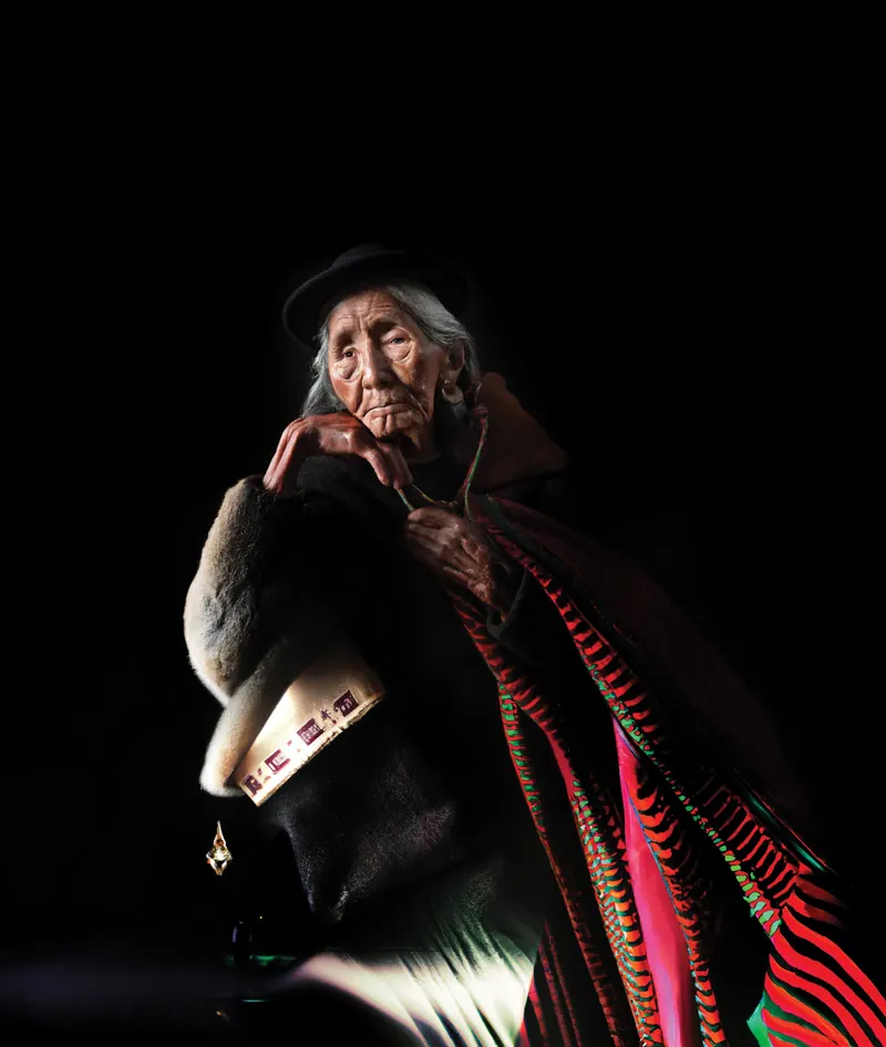 Una abuela andina generada con IA, con sombrero y una manta roja y negra.