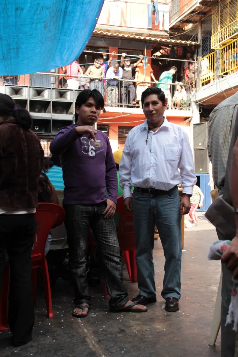 Hombres de pie en un patio angosto de la cárcel. Cárcel de San Sebastián, Cochabamba.