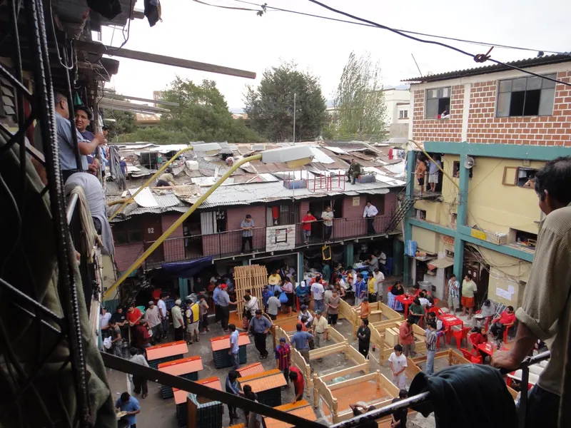 El patio de una cárcel visto desde arriba, lleno de gente, puestos y techos de calamina. Cárcel de San Sebastián, Cochabamba.