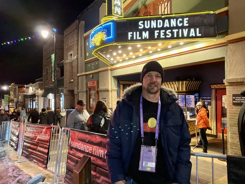 Una persona de pie frente a una marquesina del Festival de Cine de Sundance, al atardecer. Festival de Cine de Sundance.