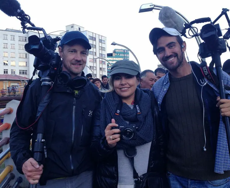 Tres cineastas muy juntos, con cámaras y micrófonos.