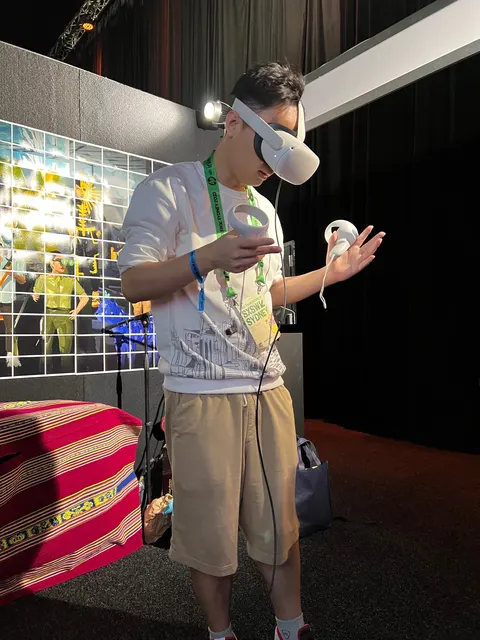 Una persona joven con un visor de realidad virtual mueve las dos manos con los controles.